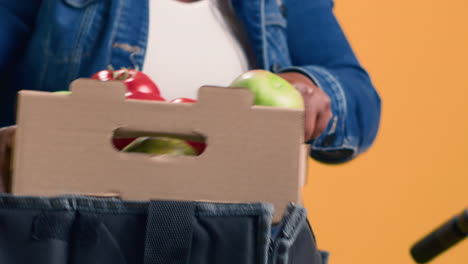 woman holding box of fresh produce