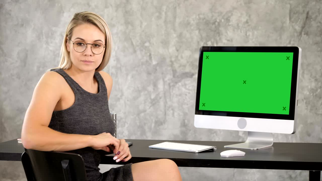 mujer profesional inteligente cerca de la computadora. pantalla verde muestra de maqueta