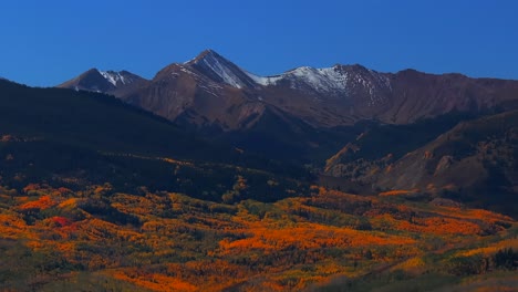 Fall Autumn sunny blue sky morning Capitol Peak Mount Snowmass aerial drone Colorado vibrant yellow orange Aspen White River National Forest snow dusting Rocky mountain peaks parallax circle right