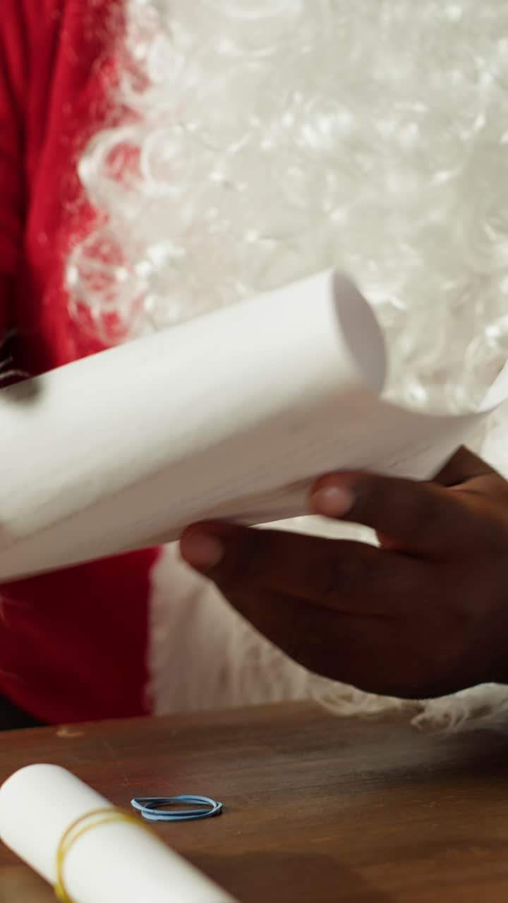 Santa's Hands Unrolling and Reading a Christmas Letter