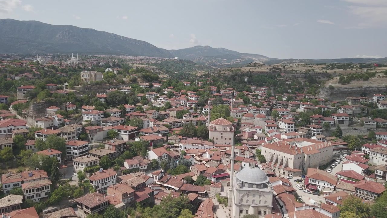 Türkiye, Safranbolu'da Geleneksel Kırmızı Çatılı Evlerin ve Tarihi Camilerin Üzerinden İleriye Doğru Yapılan 4K 10-bit Alçak Uçuş Drone Çekimi