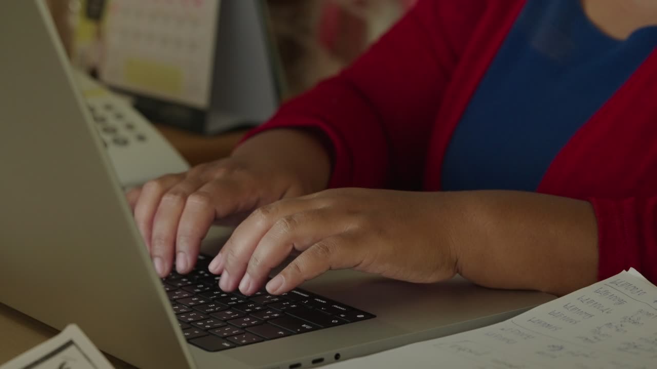 cerrar las manos de una mujer de negocios escribiendo investigación en la palabra clave de la computadora portátil e hizo un informe de negocios en el escritorio de la oficina por la noche.