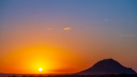 Un-Amanecer-Ardiente-En-El-Paisaje-Del-Desierto-De-Mojave-Con-Una-Colina-En-Silueta---Lapso-De-Tiempo