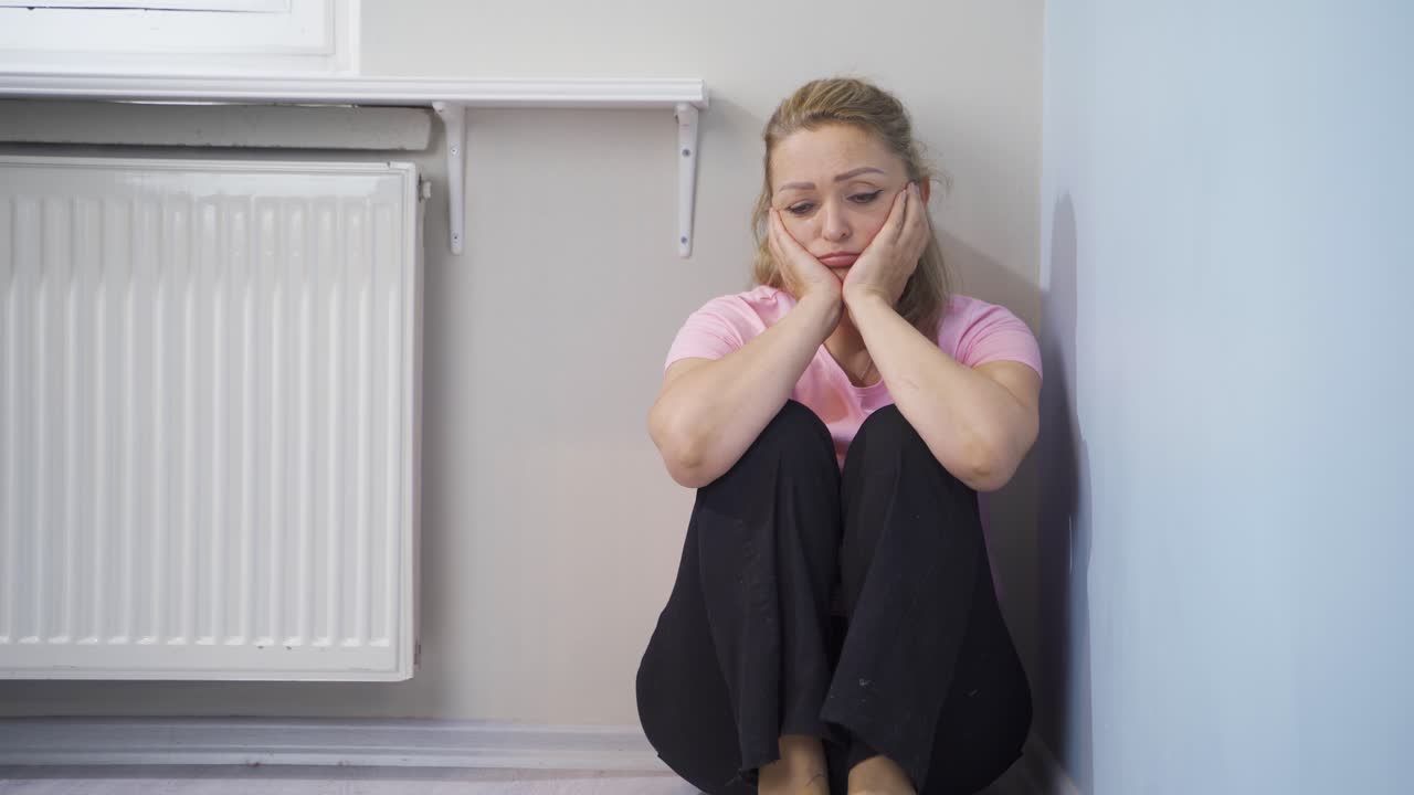 우울한 여성이 손으로 얼굴을 가리고 있습니다.