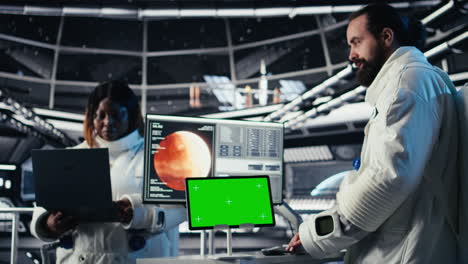 astronaut monitoring system on isolated screen tablet, chatting with colleague