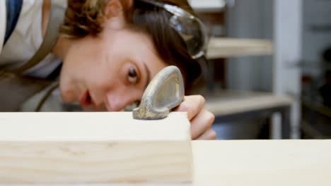 female welder using a clamp on wooden plank 4k