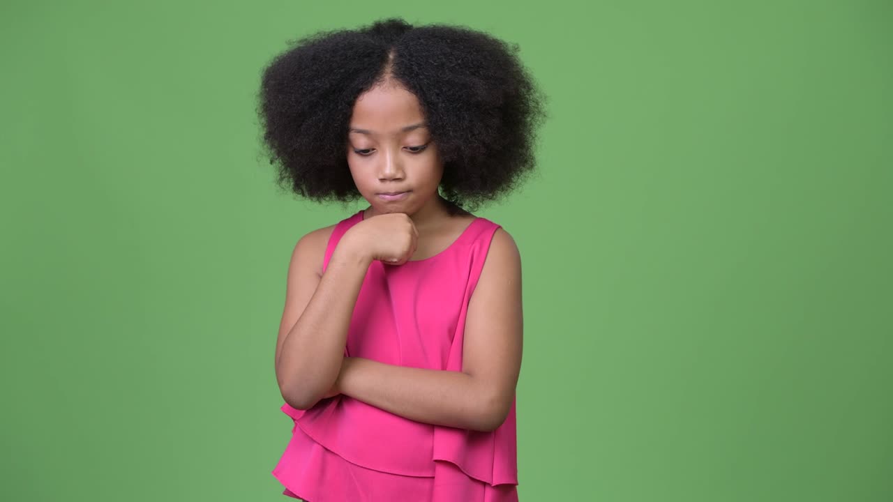 Young sad African girl with Afro hair thinking while looking down