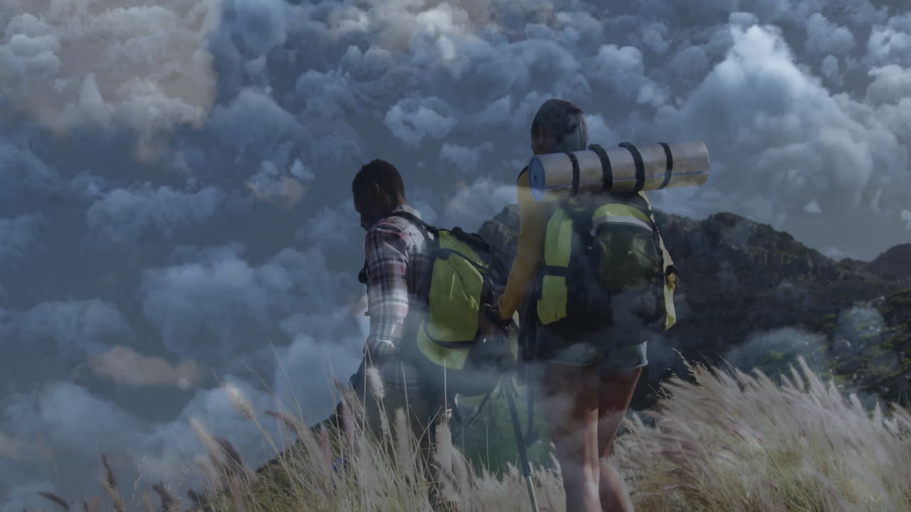 woman and man hiking traversing grassy slope, showing animated health heart icon and data chart