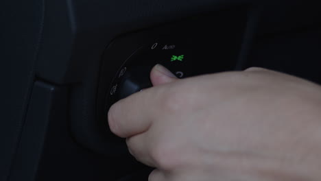 close-up of turning the knob to switch on and off the car headlights