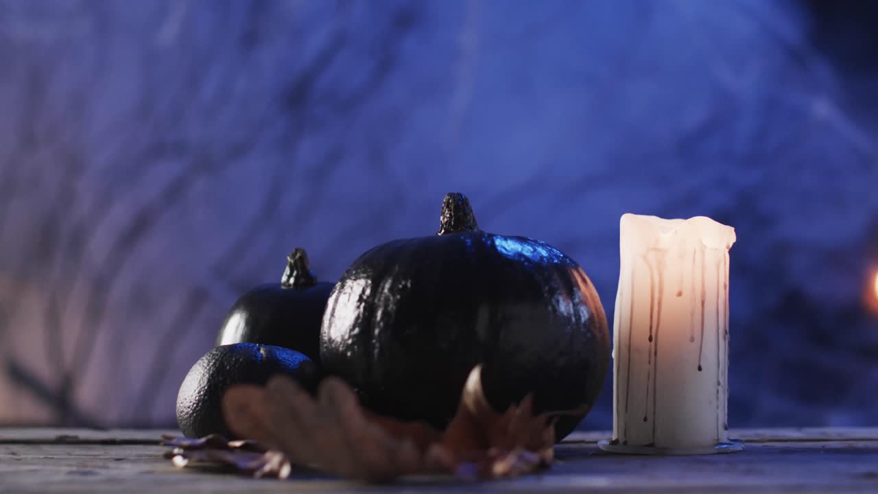 Video of halloween pumpkins, candle and smoke with copy space on purple background
