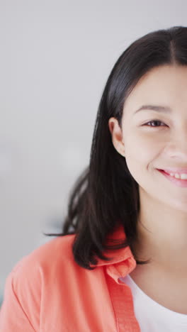 vertical video of smiling biracial woman with dark hair looking at camera