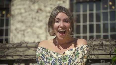 Argentinian-woman-eccentrically-laughing-for-the-camera-in-a-off-shoulder-neck-top