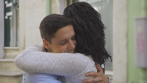 handsome caucasian man hugging african american woman.