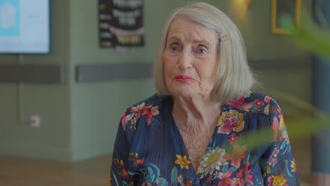 slow motion shot of a elderly woman speaking with a relative in a retirement home