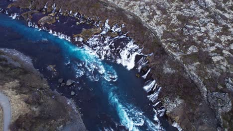 drones cinematográficos que establecen la impresionante cascada de hraunfossar en islandia, en órbita aérea