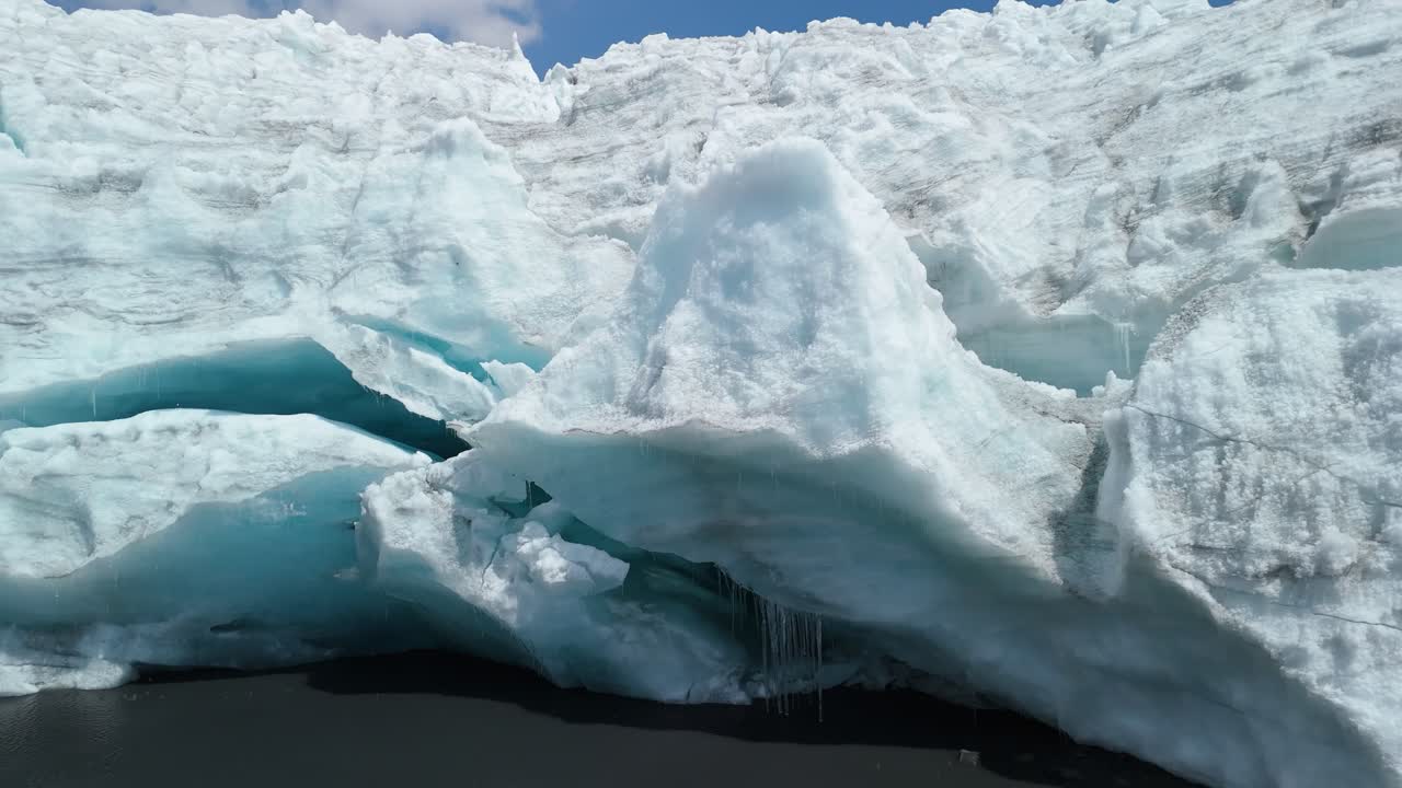 A dramatic aerial parallax shot reveals the sprawling and fractured ice of the Pastoruri Glacier in Peru's Cordillera Blanca. The high-altitude glacier, which rapidly retreats due to climate change