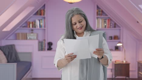 una vieja india feliz leyendo informes.
