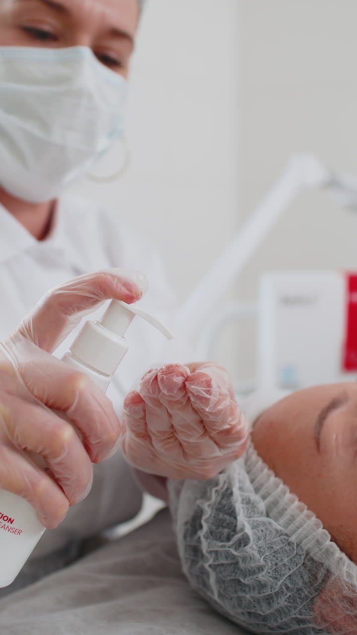 cosmetólogo preparándose para aplicar exprime la espuma de lavado de la botella hidratante pelado de la mujer cara