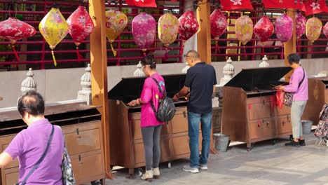 people engaging in a temple ritual with lanterns