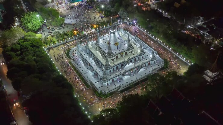 Vista aerea in time-lapse di una grande pagoda nel tempio di Asokaram a Samutprakarn, vicino a Bangkok, Thailandia, durante il festival buddista di Asalha Puja (Asanha Bucha), che si svolge tipicamente a luglio, in occasione della luna piena.