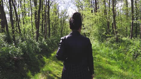 Girl-walking-through-a-narrow-path-in-the-forest