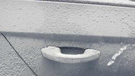 deatails of frost covered car doors during cold winter morning