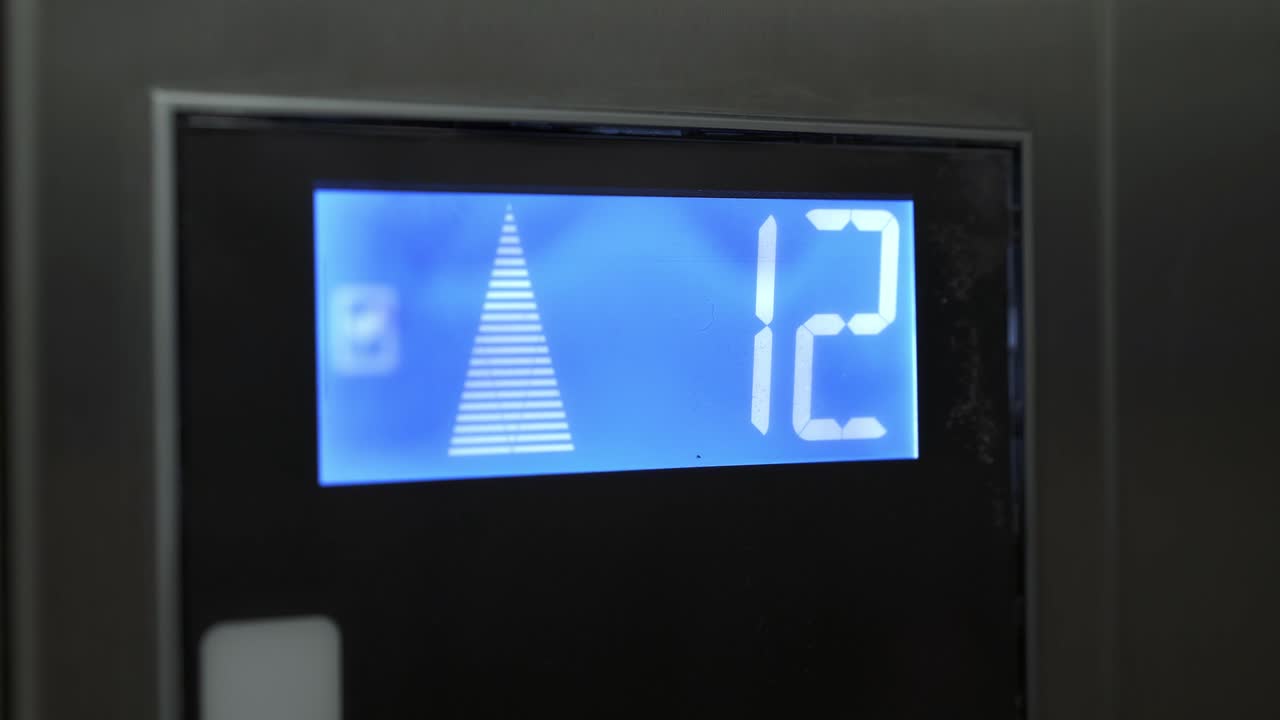 pantalla de led del ascensor gris que se eleva, desde el noveno hasta el decimoquinto piso