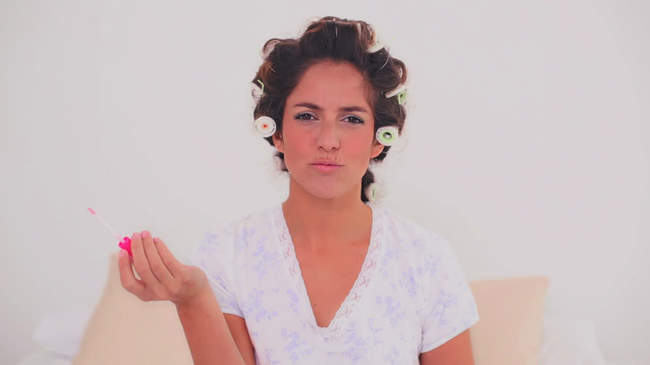 mujer feliz con rizos de cabello aplicando brillo