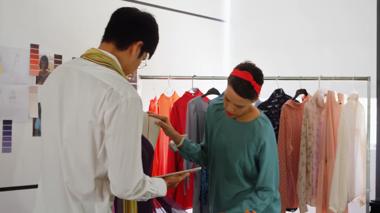 diseñadores de moda de raza mixta discutiendo sobre una tableta digital en el taller 4k