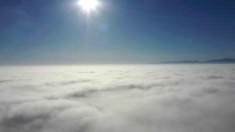 panorámica a través de lecho blanco de nubes contra la luz del sol brillante