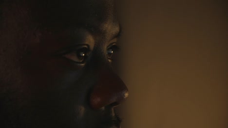 close up of black male eyes looking at computer screen