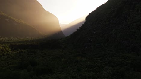 Sonnenlicht-Strömt-Atemberaubende-Dicke-Strahlen-Goldenen-Lichts-über-Den-Berggipfel-Im-Schattigen-Tal