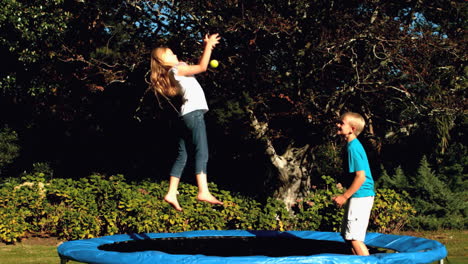 hermanos jugando juntos en un trampolín