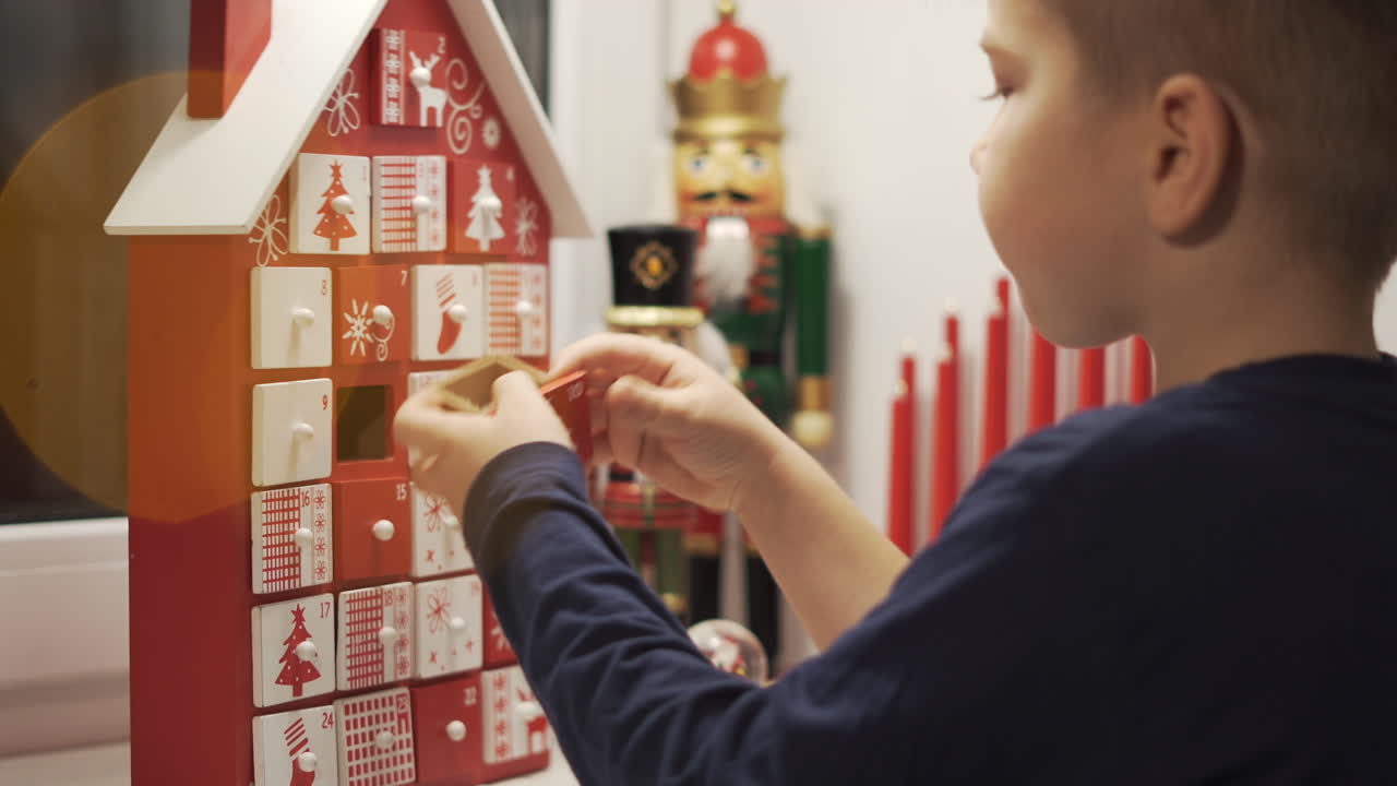 Happy Little Boy Takes Sweet From Advent Calendar House Form With Christmas Nutcrackers in Background-1
