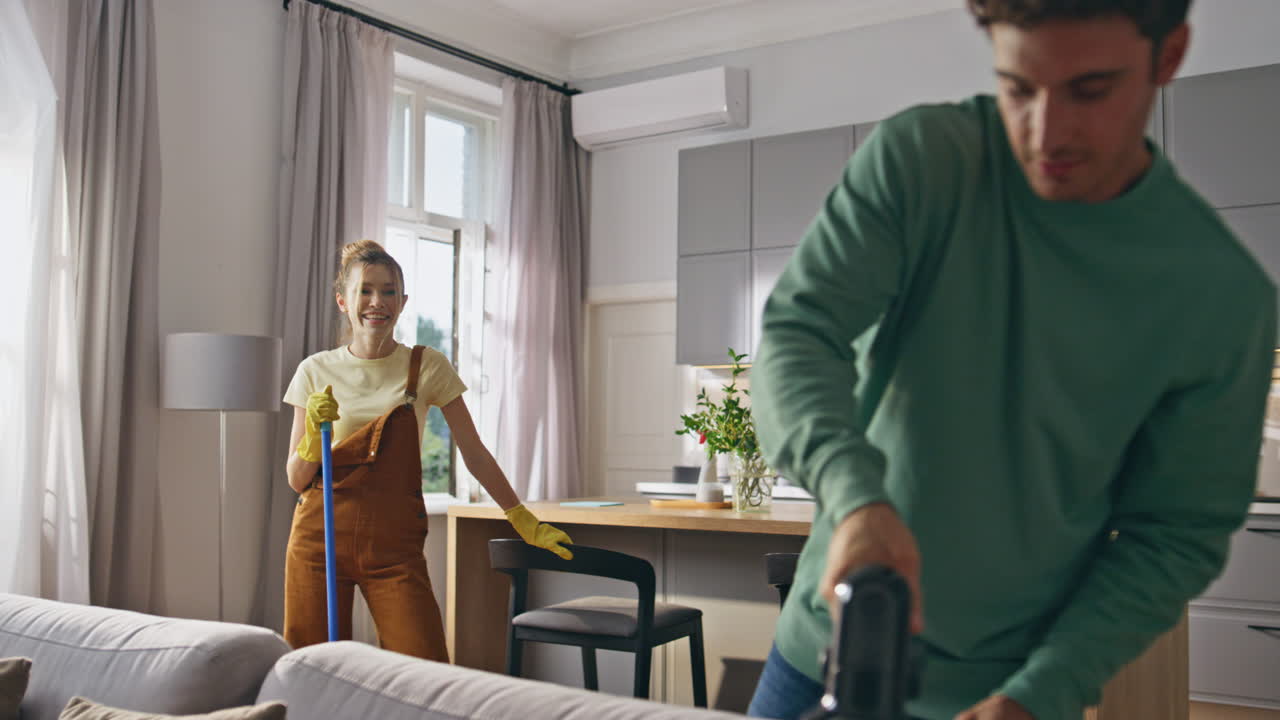 Young couple doing housework and chores at kitchen closeup. Cleaning concept