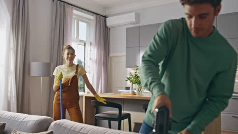 young couple doing housework and chores at kitchen closeup. cleaning concept