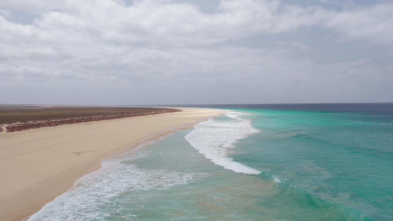 Drone footage of Santa Monica Beach,showcasing endless white sand, turquoise waves, and a pristine,summer concept,Boa Vista, Cape Verde