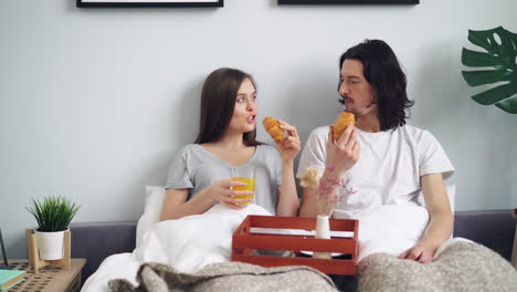 pareja disfrutando del desayuno en la cama