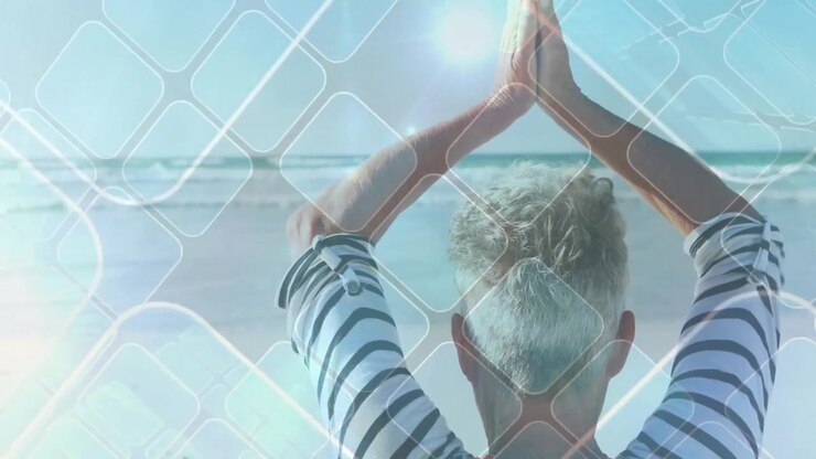Donna anziana che pratica yoga sulla spiaggia al tramonto