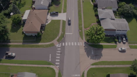 empuja una calle suburbana tranquila con autos que se detienen en la intersección