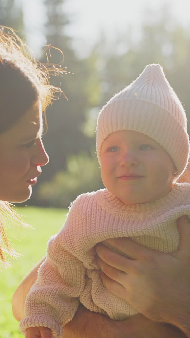 Genitori felici che baciano il loro bambino in un parco soleggiato