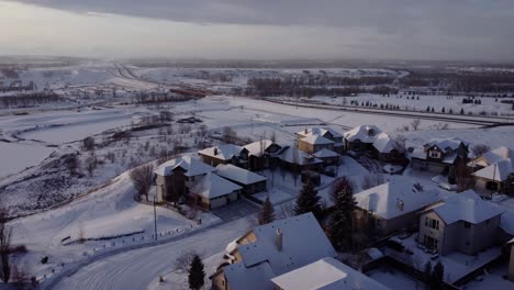 flying over community covered in snow in winter time