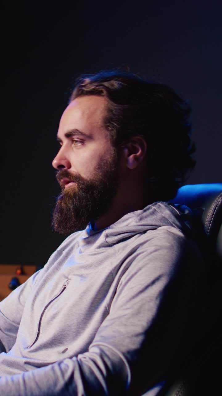 Vertikal video av en Pro-gamer som konkurrerer i et intenst online multiplayerspill, skyter fiender med en futuristisk pistol