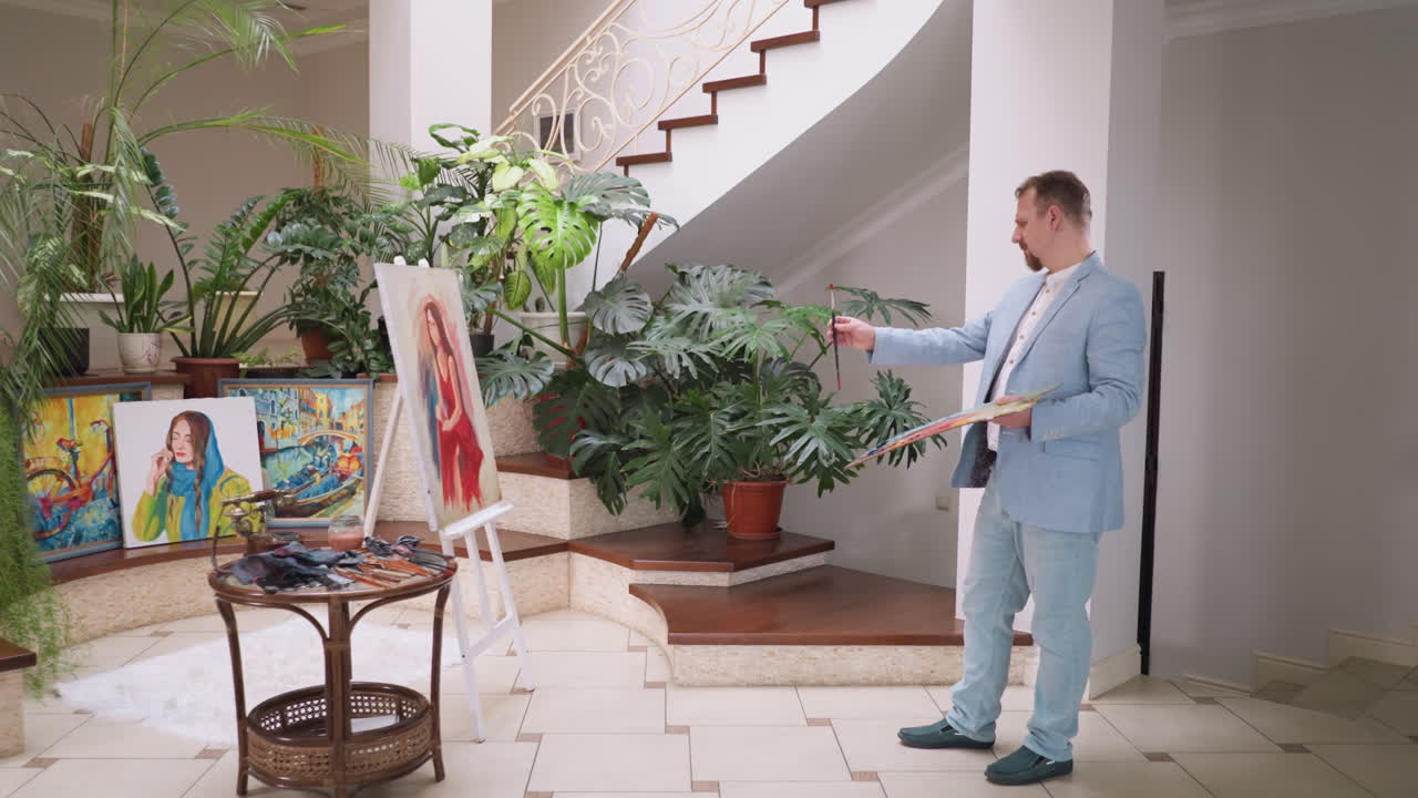 hombre artista comprueba los resultados de las pinturas. hombre hábil artista transforma lienzo en blanco en la representación cautivadora de la mujer en el estudio de arte moderno