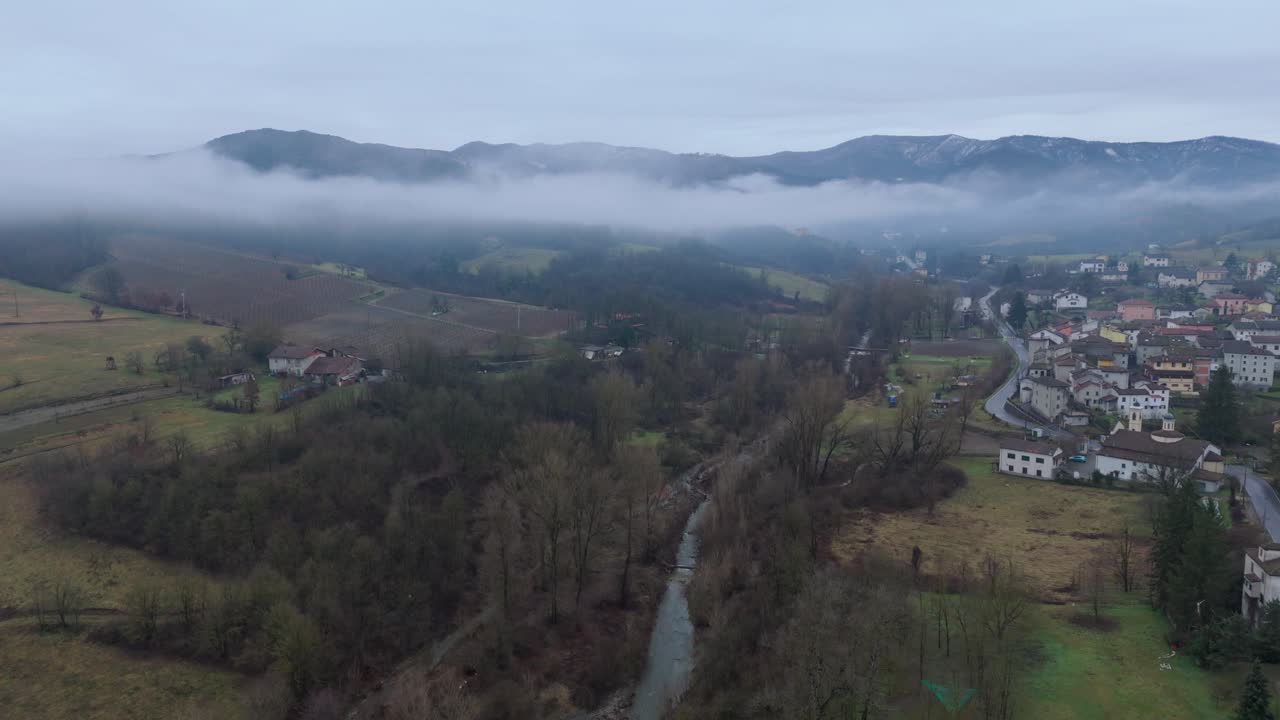 nube de niebla sobre el campo valle del río con el pueblo y el cielo nublado