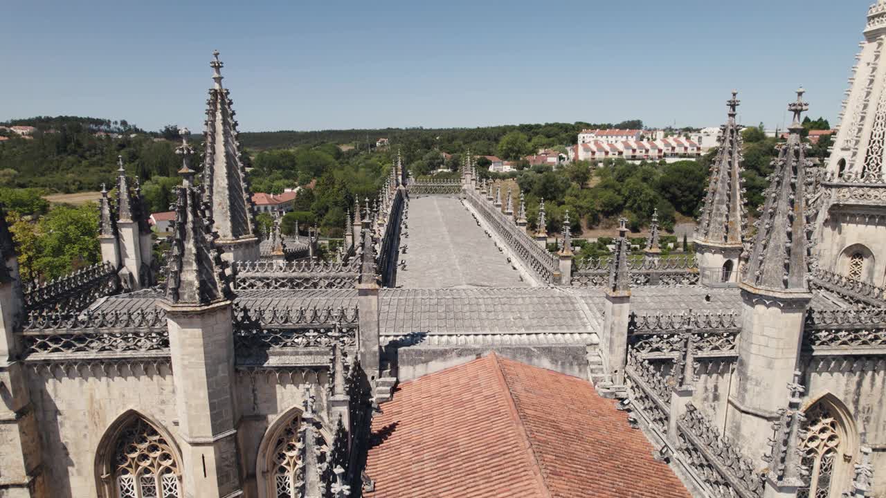 drone volando sobre la azotea con agujas góticas del monasterio de batalha