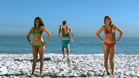 mujeres arrojando su cabello mientras un amigo está corriendo hacia el mar