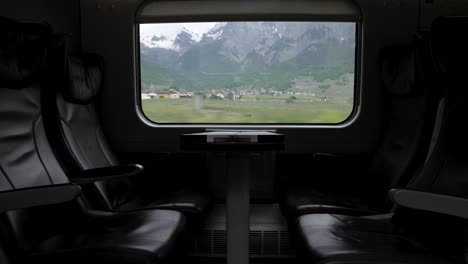 empty leather business class seats - travelling through switzerland with train through scenic landscapes