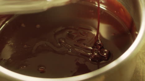 mixing liquid chocolate with whisk in slow motion. closeup liquid hot chocolate.