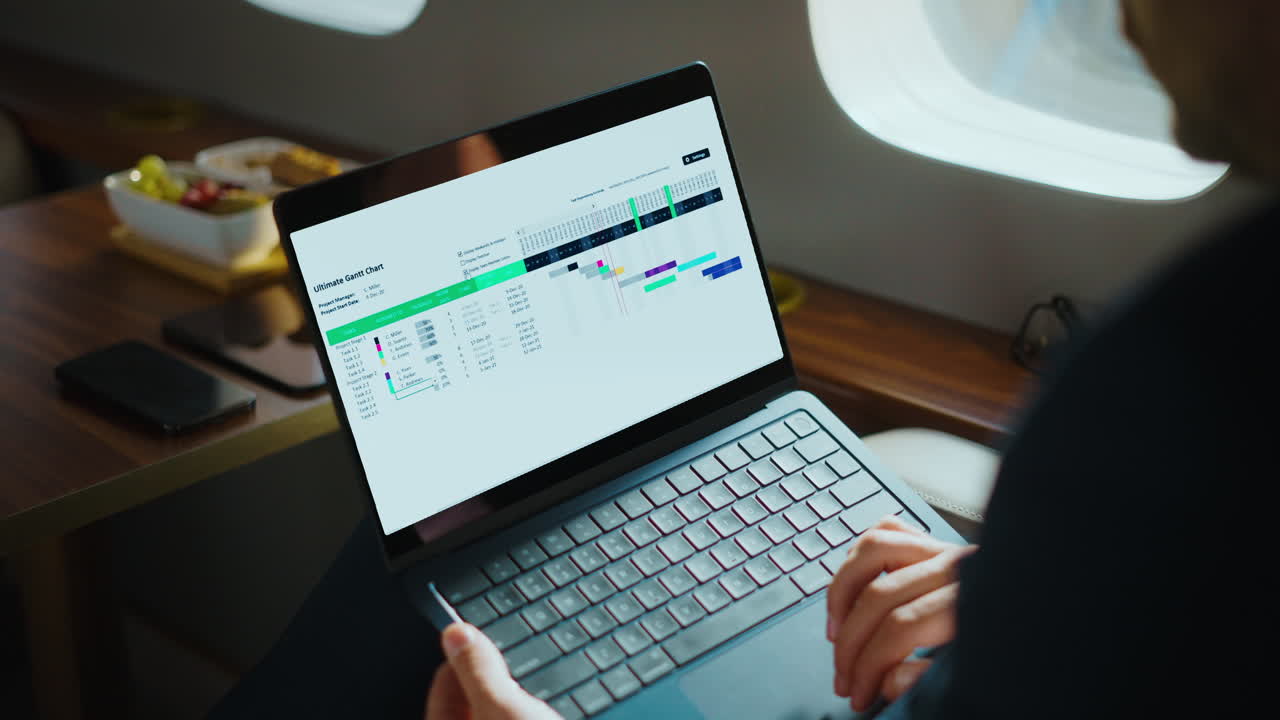Businessman working on a chart on a laptop in a private jet
